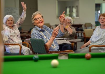 Retirees enjoying watching a game of billards